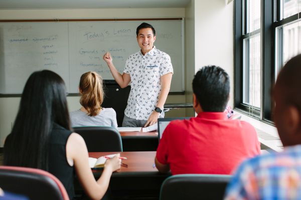 man teaching english to students