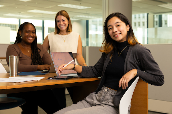 3 students at table smiling